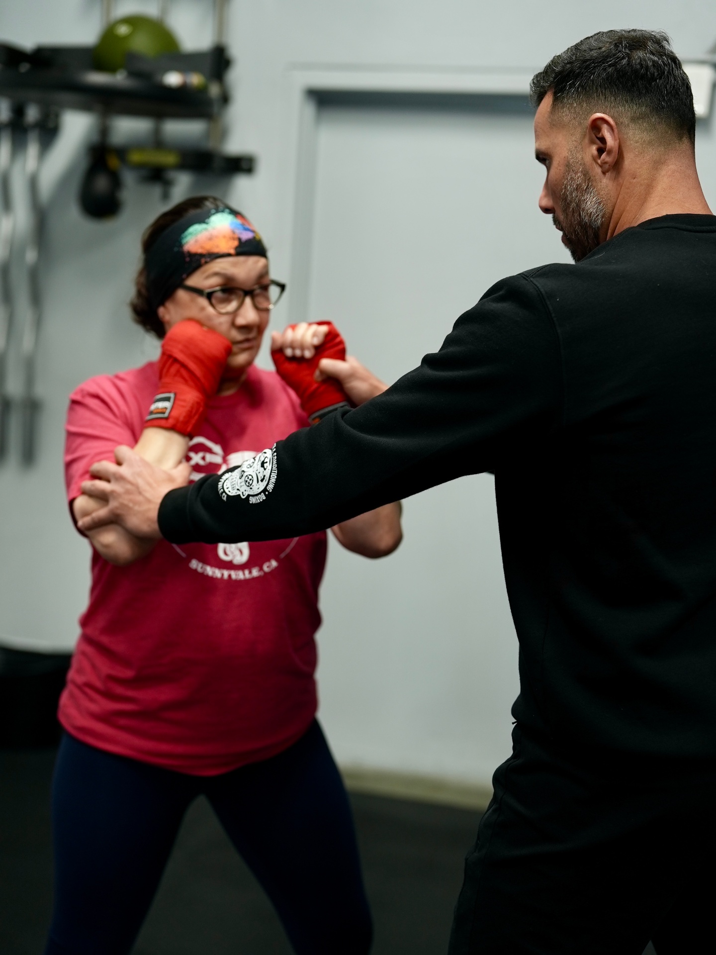 Coach guiding a beginner student through boxing fundamentals at XP360